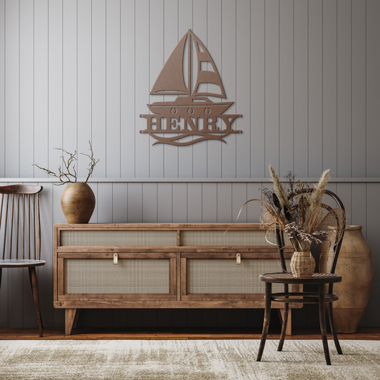 A copper-finished personalized sailboat name sign, featuring the name "James," hanging on the wall of a rustic, nautical-themed nursery above a crib.