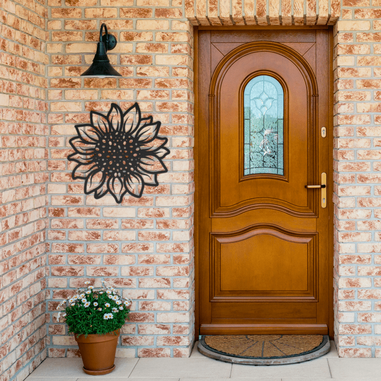 Bold black sunflower metal wall art mounted on a rustic brick entryway wall, creating a dramatic and welcoming vibe at the home’s front door.